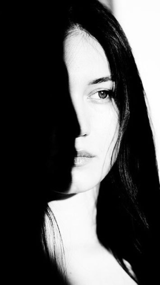 Portrait artistique en clair-obscur, visage à moitié dans l'ombre